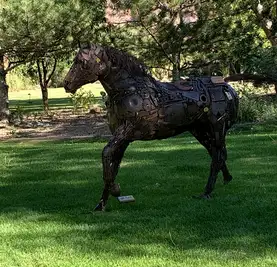 metal horse art with standin in the grass